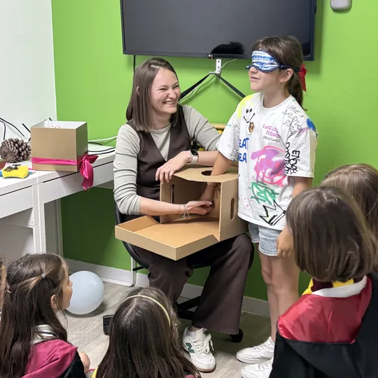 Monitora entregando una prueba a los niños en el escape room