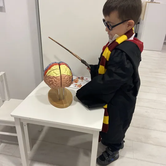 Niño con capa de mago durante la fiesta de Harry Potter