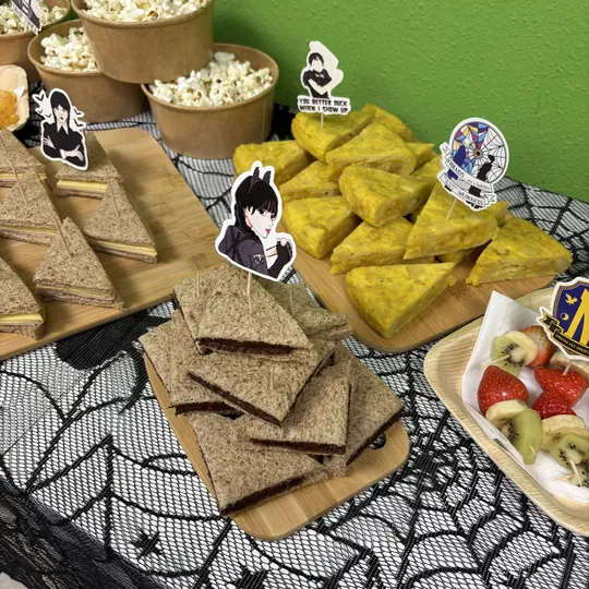Mesa temática de Wednesday con snacks y telarañas