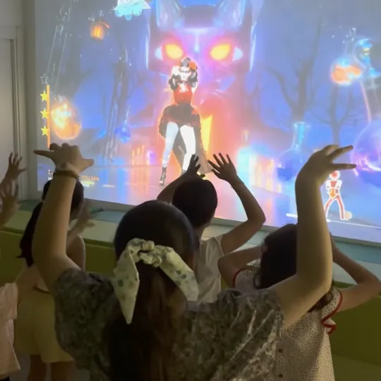 Niños ante la proyección interactiva en la fiesta de Wednesday