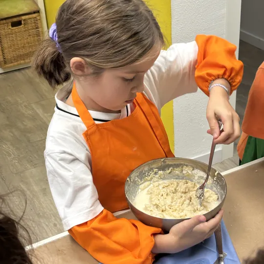 Niña preparando la masa de los gofres