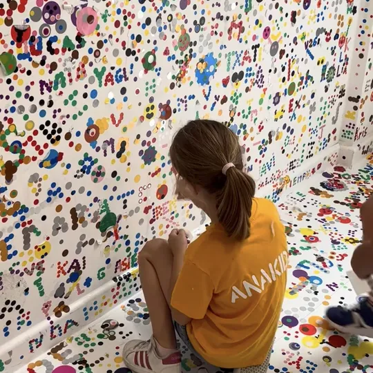 Niña ante un mural de colores durante una excursión