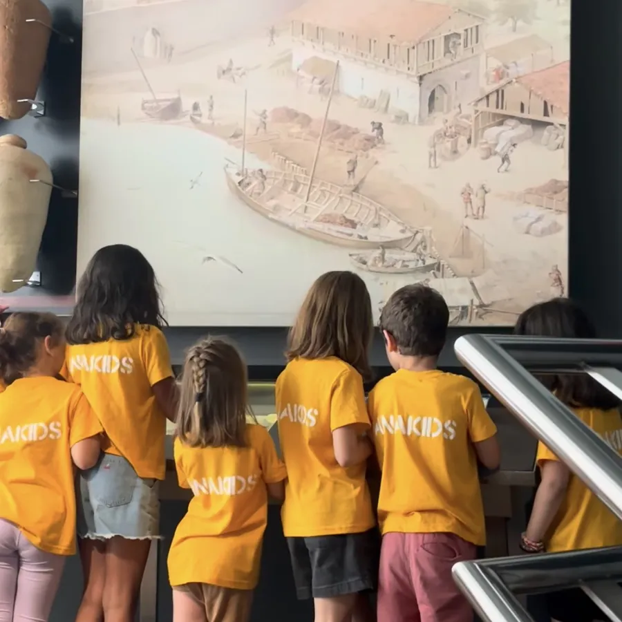 Niños observando una maqueta en un museo de Bilbao durante las colonias
